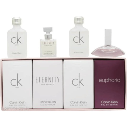 Calvin Klein fragrance gift set featuring three white bottles, a small clear bottle with a silver cap, and a pinkish perfume bottle displayed above their matching white and deep purple boxes.